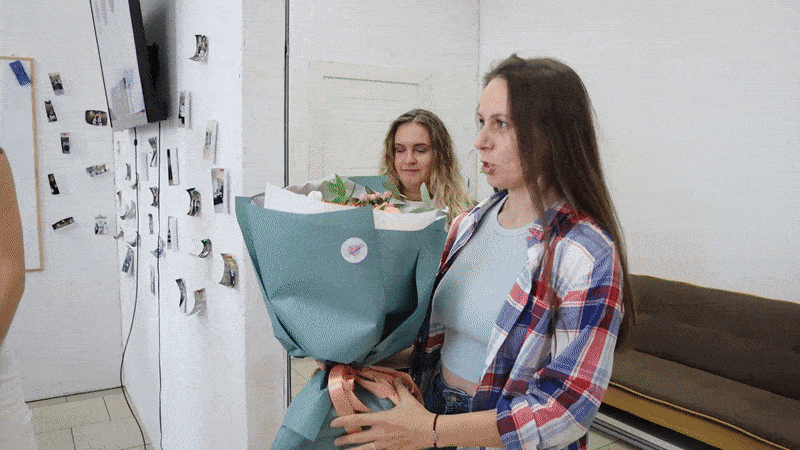 Выпускница школы дизайна держит букет